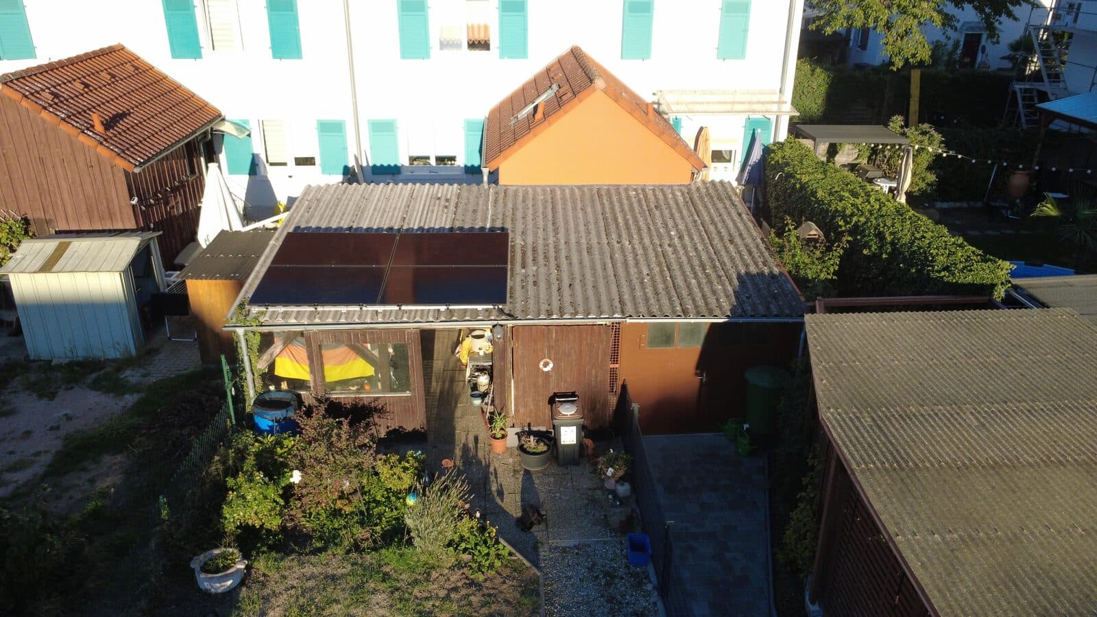 Balkonkraftwerk mit vier Solarmodulen auf dem Dach eines Gartenhauses in Weil am Rhein, Luftaufnahme