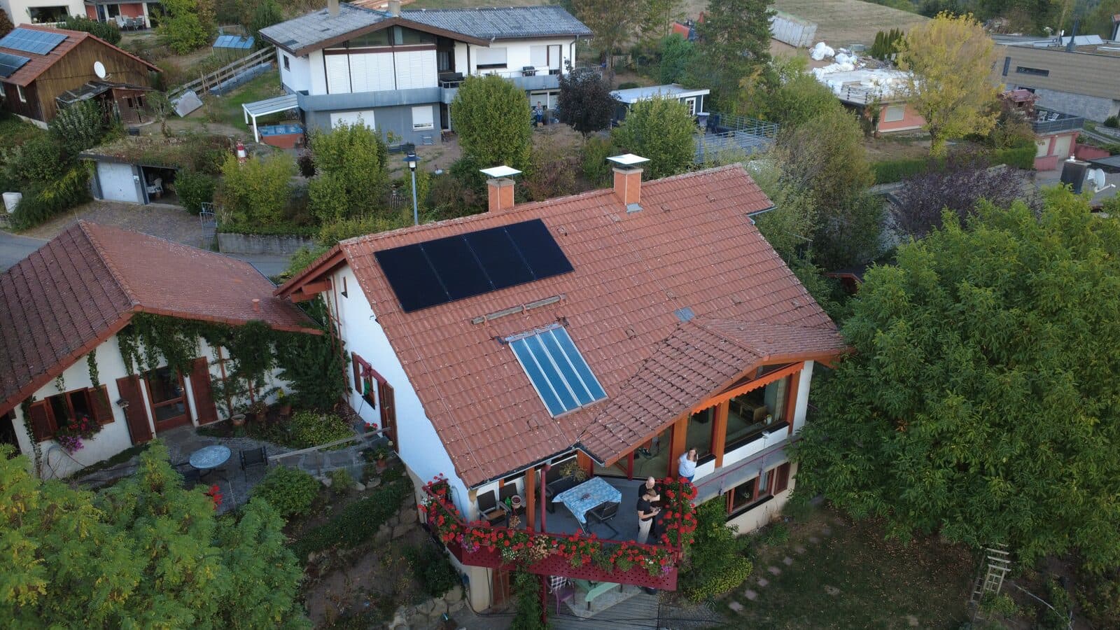 Balkonkraftwerk mit vier Solarmodulen auf einem roten Ziegeldach in Steinen im Wiesental, Luftaufnahme