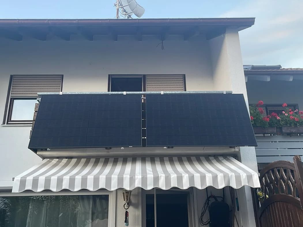Zwei Solarmodule am Balkongeländer über einer Markise