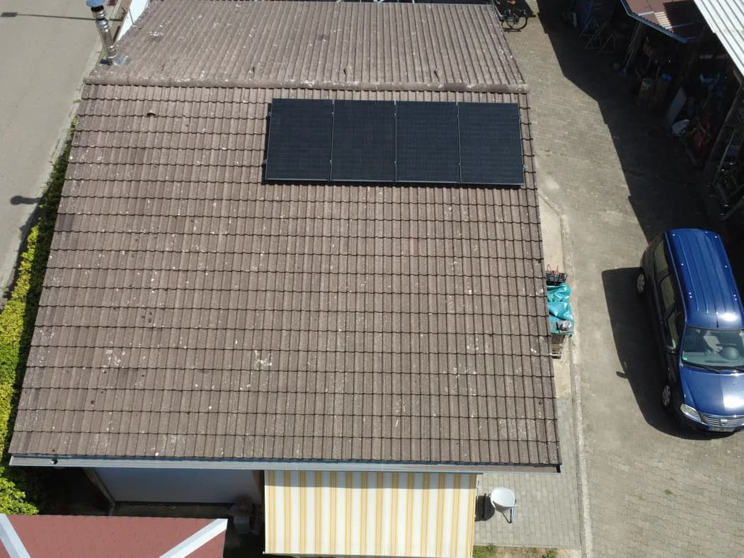 Vier Solarmodule auf einem Ziegeldach, aus der Luft fotografiert