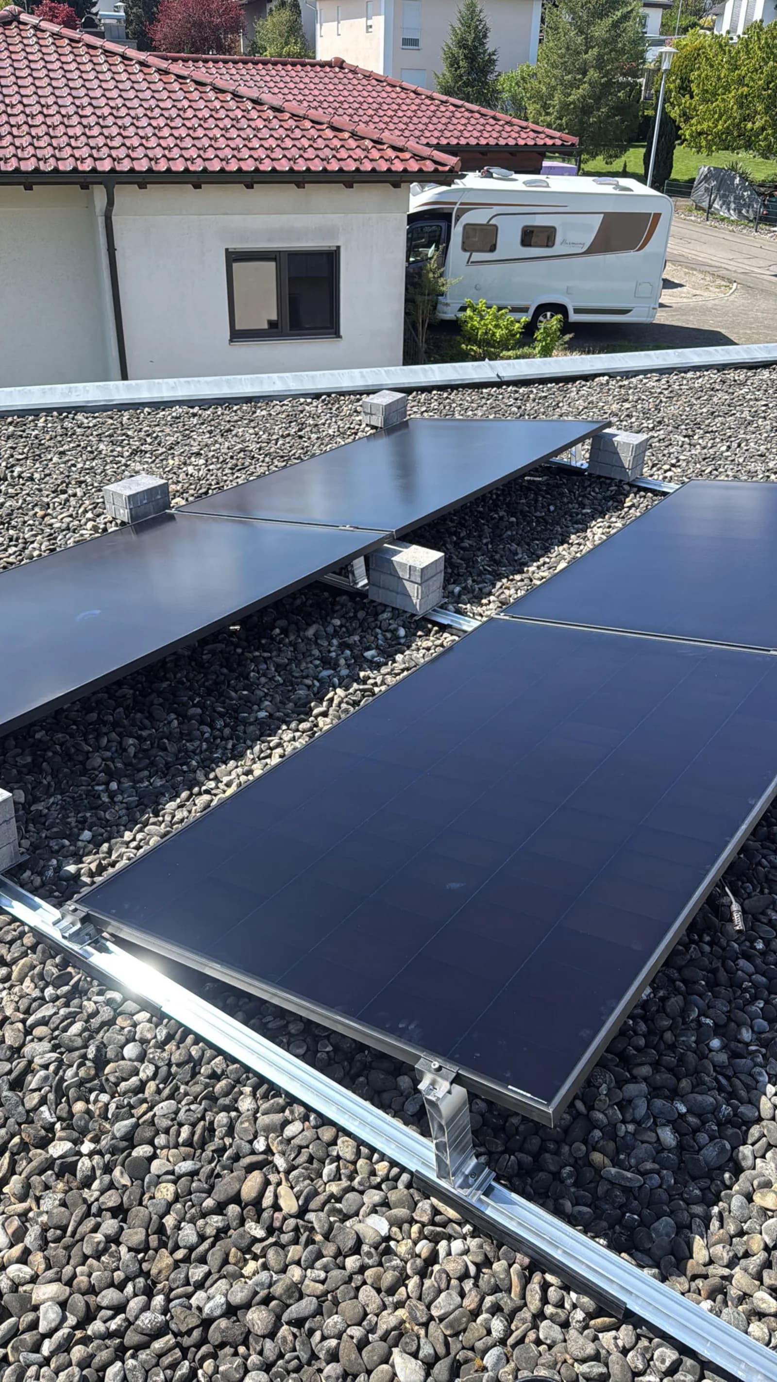 Aufgeständerte Solarmodule auf einem Kiesflachdach