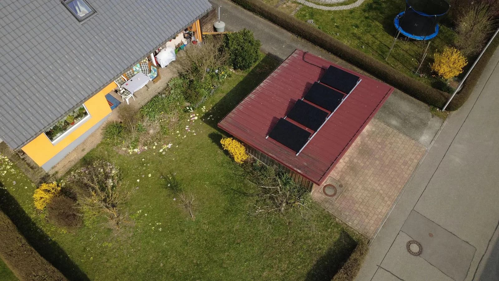 Vier Solarmodule auf einem Garagendach, aus der Luft fotografiert
